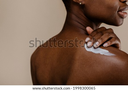 Black woman applying body cream ストックフォト © 