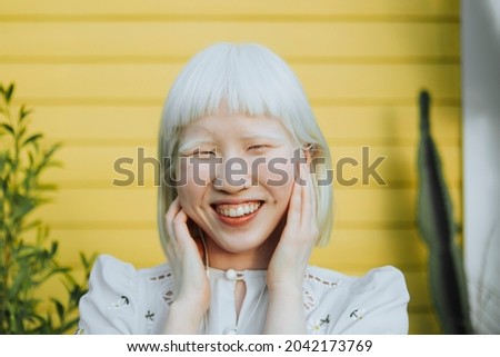 Cute albino girl listening to her favorite music through earphones Imagine de stoc © 