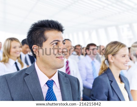 Businessman smiling among the other business people