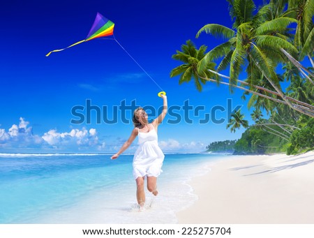 Woman flying a kite on the beach.