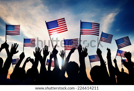Group of People Waving American Flags at Sunset
