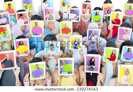 Multi-ethnic group of people holding tablets in front of the faces