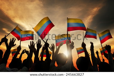 Group of People Waving Columbian Flags in Back Lit