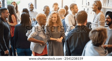 Diverse group of people socializing at a casual gathering. Men and women of various ethnicities engaged in conversation, enjoying a lively social event. Diverse people mingle at a social event.