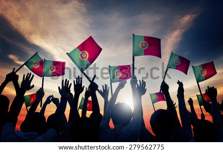 Group of People Waving Portuguese Flags in Back Lit Concept