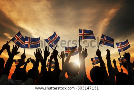 Group of People Waving Icelandic Flags in Back Lit