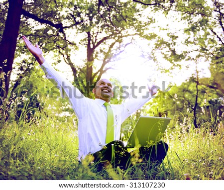Businessman Sitting In a Forest With His Laptop Concept