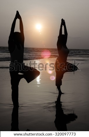 Serene People In The Beach Doing Yoga In The Sunset Concept