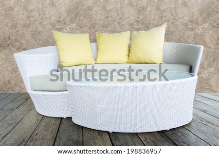 sofa furniture weave bamboo stick chair with yellow pillows on wood and grunge concrete wall