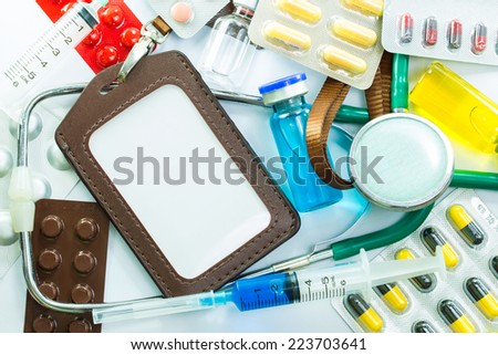 Leather name Tag with Medical frame of Stethoscope pill ampules and syringe isolated on white background