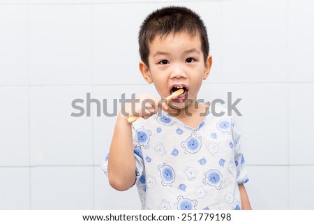 Little handsome Asian boy brushing Teeth in bath