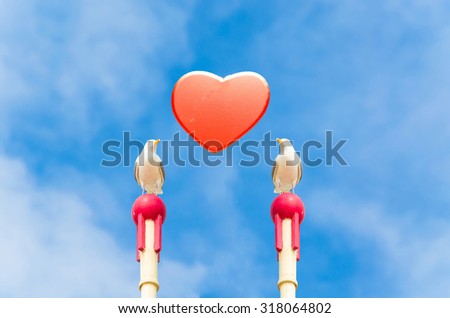 Two large seagull sitting on a wooden post. In the middle of a red heart in front of blue sky. Symbol of love. Stock foto © 
