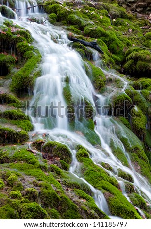 waterfall on mountain stream on green moss