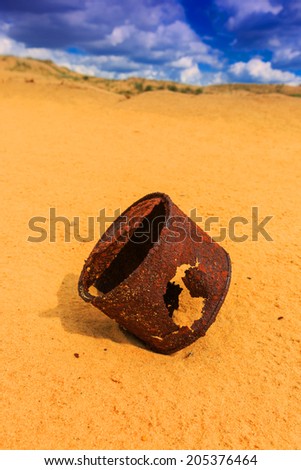 broken rusty can on sand in desert