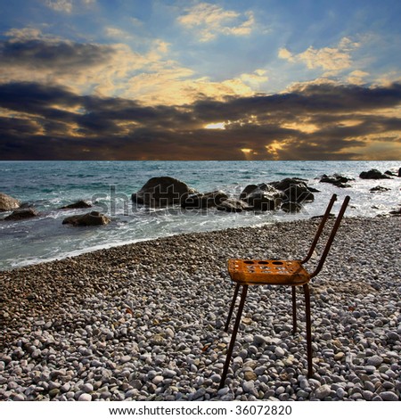 old lost chair on beach with sunset background