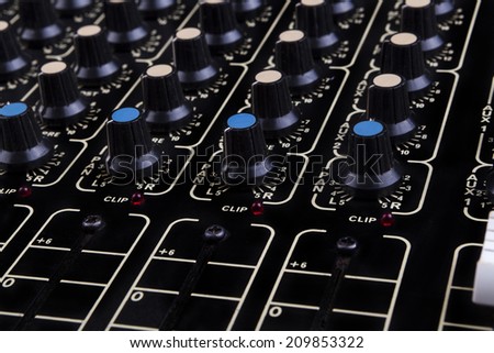 Analog studio sound mixer closeup with colored knobs