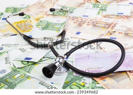 Black stethoscope  on pile of euro banknotes closeup isolated on white background