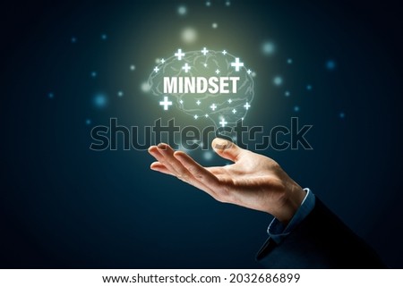 Positive mindset motivation concept with hand and graphics with symbols of brain, plus and text mindset. Be optimistic even in times of crisis motivation.