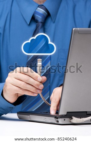 Cloud computing concept. Man send data from laptop to cloud represented by icon via ethernet cable. Selective focused on cable.