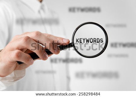 Find keywords concept. Marketing specialist looking for keywords (concept with magnifying glass).