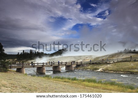 People crossing bridge over the Firehole River in the Midway Geyser Basin of Yellowstone National Park.