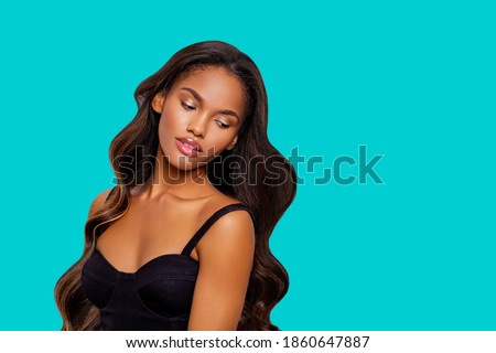 Beauty styled portrait of a young African American woman. makeup. Fashion black girl with curly hair posing in the studio on a  turquoise background. isolated. Studio shot.                           