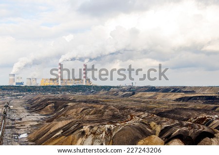 A view on an open pit mine with power plant in the background