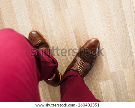 Sockless male legs in two tone suede brogues, Stylish dressed man wearing cushioned pants and wingtips