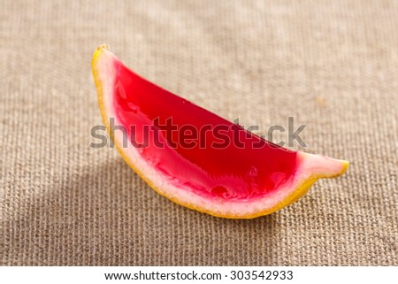 Lemon tequila strawberry jelly (jello) shot on a linen clothed table. Unusual adult party drink
