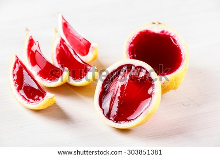 Vodka  jelly (jello) shots made out of carved lemon on bleached wooden tablle. Unusual adult party drinks