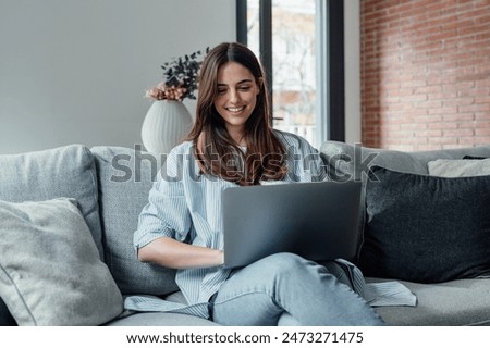 Image, Stock Photo The young woman in the blue sweater sits comfortably in the armchair and holds a coffee mug and a book in her hands. Upper body portrait without head