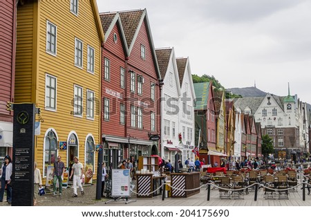 BERGEN, NORWAY - JUNE 5: Tourists walking on the UNESCO World Heritage Site, Bryggen, in the city of Bergen, on June 5, 2014. Bryggen is famous for its wooden buildings.