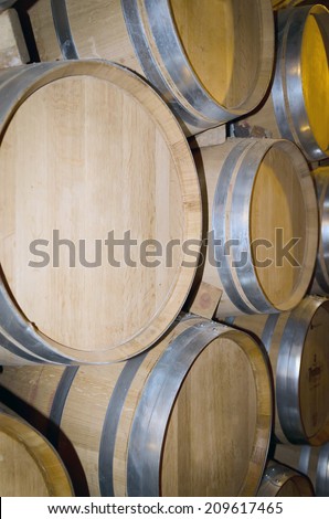 Stacked oak barrels in a winery. Winemaking industry