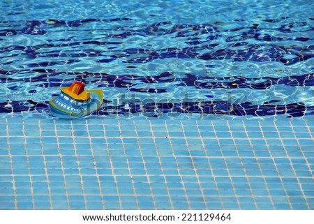 Plastic ship in the pool. Toy floating in the water