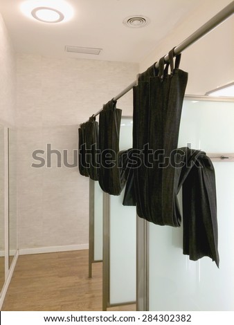 Empty fitting room in an store with mirrors and curtains