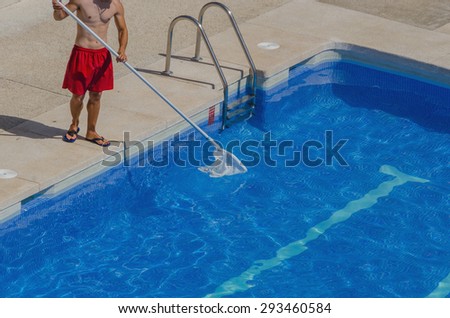 A guy is cleaning the swimming pool. Summer maintenance service
