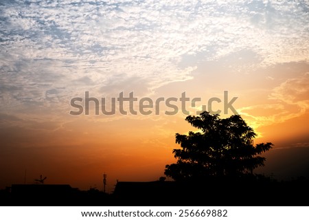 Abstract yellow cloudy sky with city silhouette in sunset hour background