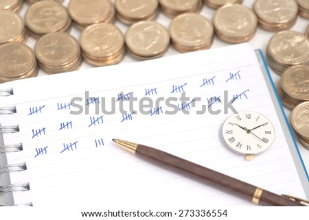 Abstract pile of money around ring bound book with mark showing amount of counted money and clock on top of the book which showing working time