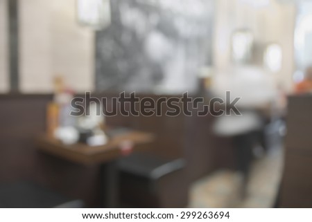 Abstract blurry dark brown restaurant interior table during dining time with unrecognizable waitress