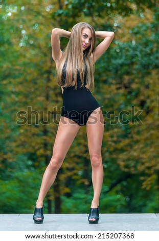 Beauty model with long legs on heels in park