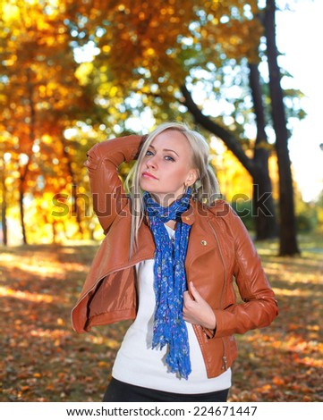 Pretty girl posing in autumn park in orange coat - nature portrait