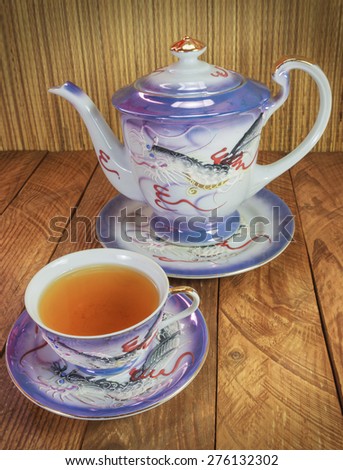 Japanese porcelain tea cup and teapot with dragon design