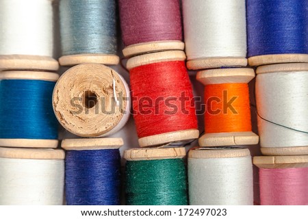 Coils of color thread on white desk, look from above