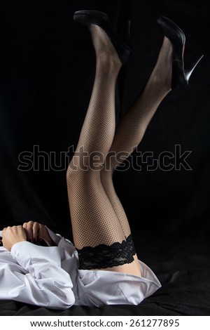 Photo of woman raised legs up on black background