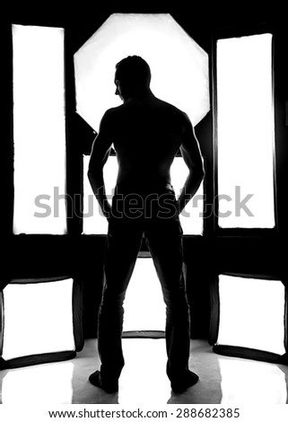 Photo of the young man amid softboxes - black and white background