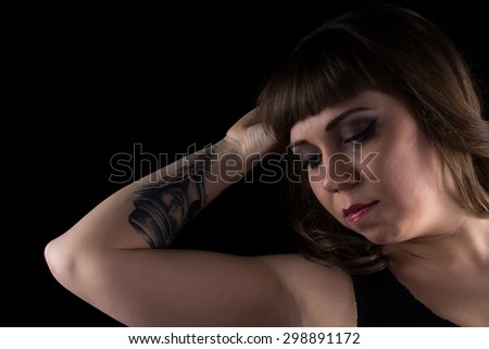 Portrait of fat woman with tattoo on hand on black background