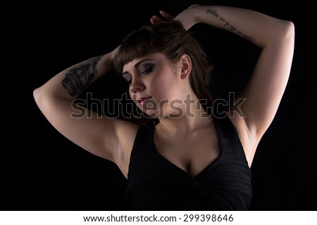 Image of fat woman with tattoo on hand on black background