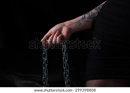 Photo of chain in woman\'s hand on black background