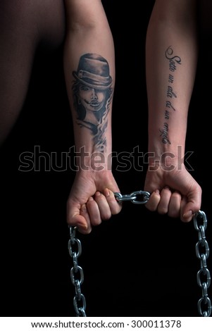 Photo of woman\'s hands holding chain on black background