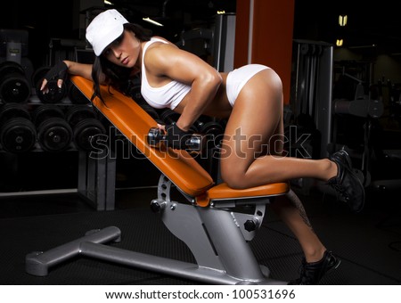 Image of muscle woman doing exercises in gym